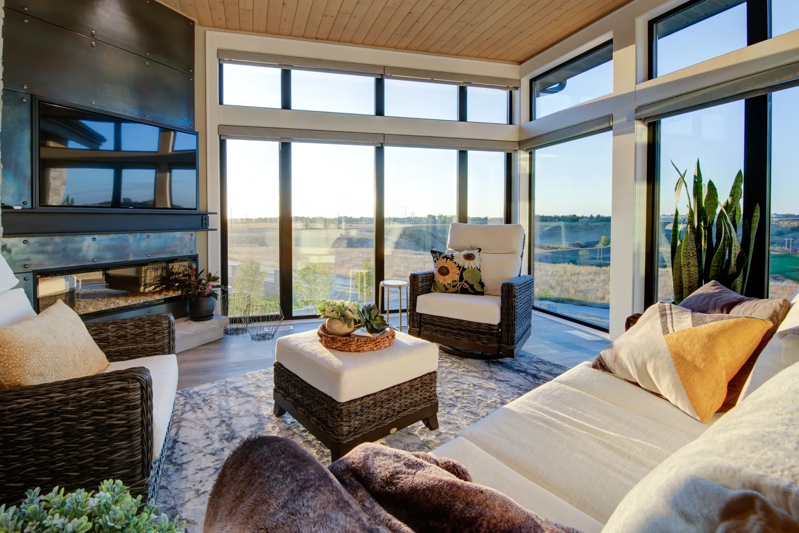 Sunlit sitting room with a timber ceiling, corner glazing and views across the prairie