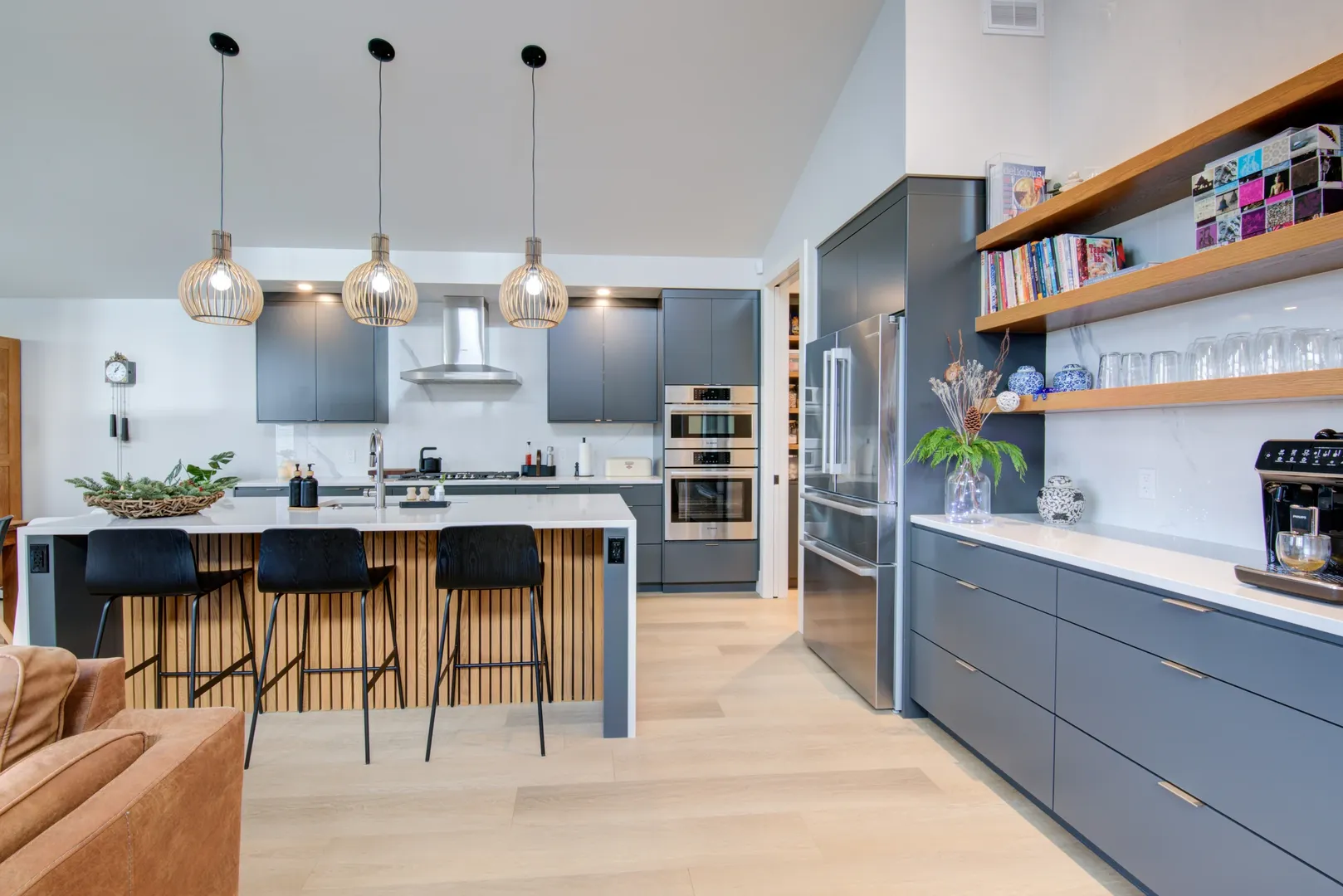 Contemporary kitchen with slate cabinetry, an oak island and sculptural pendant lights